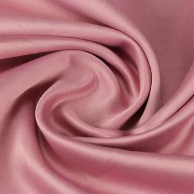 Tissu satin polyester uni rose toucher peau de pèche vendu au coupon