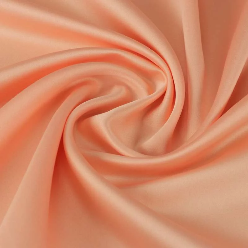 Tissu satin polyester uni saumon foncé toucher peau de pèche vendu au coupon