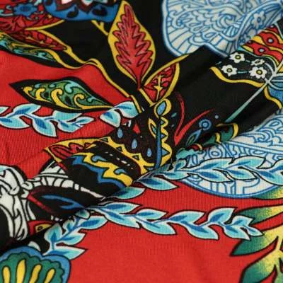 Tissu lycra maillot de bain motif feuilles tropicale sur fond rouge vendu au coupon