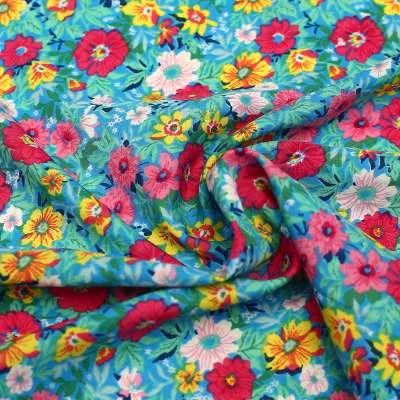 Crêpe Polyester imprimé floral sur fond aqua  idéal pour la couture de vêtements