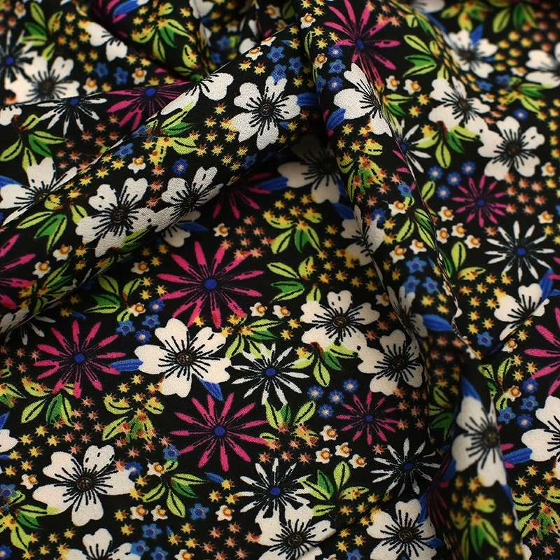 Tissu crêpe de polyester avec des motifs floraux Fond noir vendu au coupon