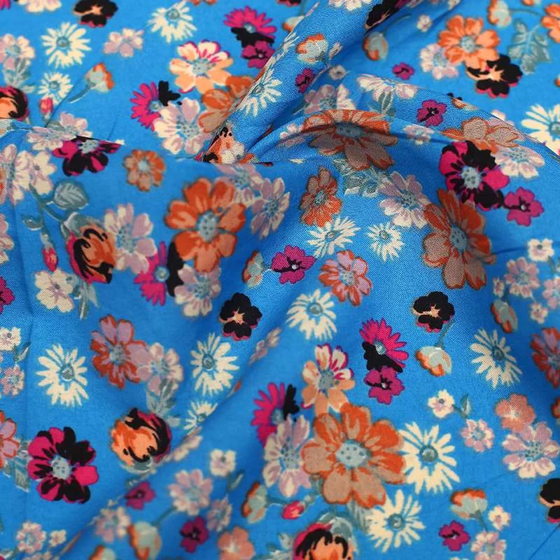 Tissu crêpe polyester imprimé fleurs sauvages fond bleu vendu au coupon