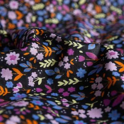 Popeline de coton noir ornée de fleurs multicolores.