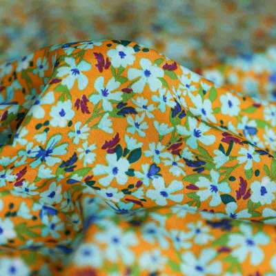 Tissu microfibre orange avec motifs floraux bleus et blancs